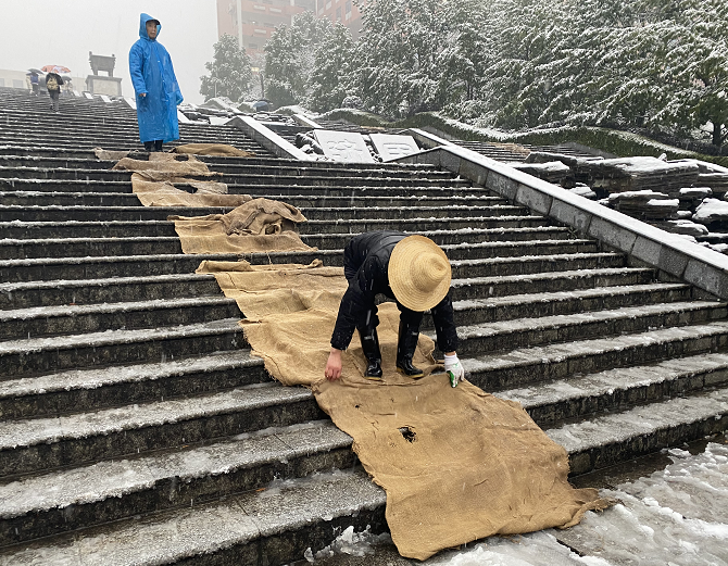 清除积雪铺设麻袋 钱能钱包积极应对低温雨雪天气